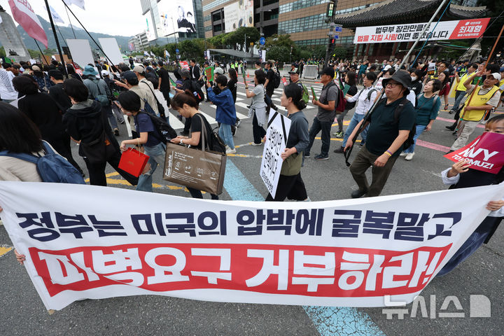 [서울=뉴시스] 황준선 기자 = 12일 서울 종로구 세종대로 사거리 인근에서 열린 '미국은 침략전쟁 중단하라! 정부는 호르무즈 파병 단호히 거부하라! 시민 대행진'에서 참석자들이 청와대를 향해 행진하고 있다. 2026.09.12. hwang@newsis.com