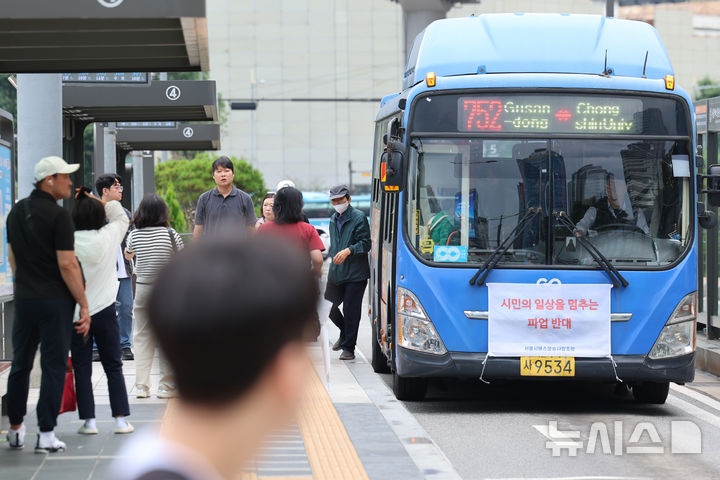 [서울=뉴시스] 권창회 기자 = 13일 서울 중구 서울역 환승센터에서 버스에 붙어있는 파업 반대 현수막. 서울 시내버스 노조가 오는 16일 쟁의행위를 예고하면서 서울 시내버스 운행이 중단될 가능성이 높아졌다. 전국자동차노동조합연맹 서울시버스노동조합은 11일 '2026년 임금협정 체결을 위한 쟁의행위 찬반투표' 결과 61개 일반버스 회사 노조원 대상 투표에서 87.94%인 1만 6,089명의 찬성으로 쟁의행위안이 가결됐다고 밝혔다. 노조는 오는 15일 제2차 조정 회의에서 협상이 결렬될 경우 16일 첫차부터 전면 파업할 방침이다. 2026.09.13. kch0523@newsis.com