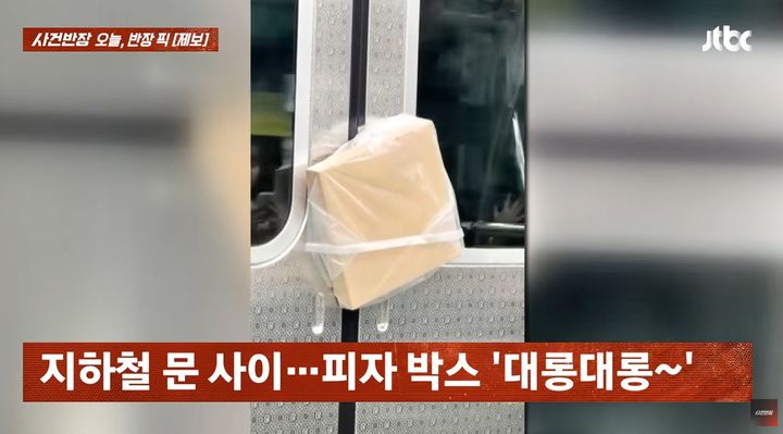 [서울=뉴시스] 지하철 문 사이에 피자가 담긴 비닐봉지가 대롱대롱 매달려있다. *재판매 및 DB 금지