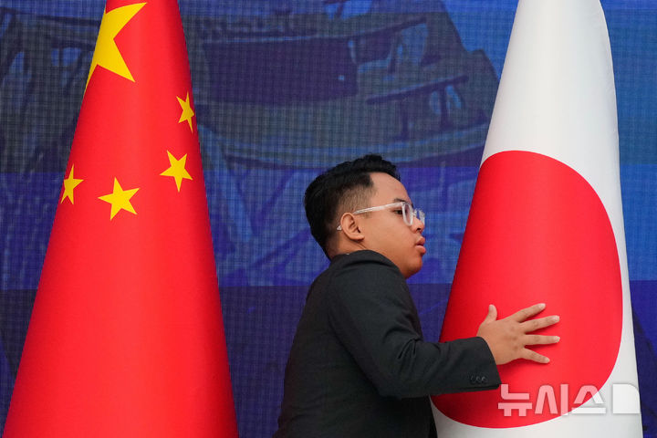 [쿠알라룸푸르=AP/뉴시스] 13일 FNN 등 일본 현지 언론에 따르면 초당파 의원 모임인 일중우호의원연맹 소속 의원 8명은 이날 베이징에 도착했다. 사진은 2025년 10월27일 말레이시아 쿠알라룸푸르에서 열린 제28차 아세안+3 정상회의를 앞두고 관계자가 중국 국기(왼쪽)와 일본 국기를 정리하는 모습. 2026.09.14.