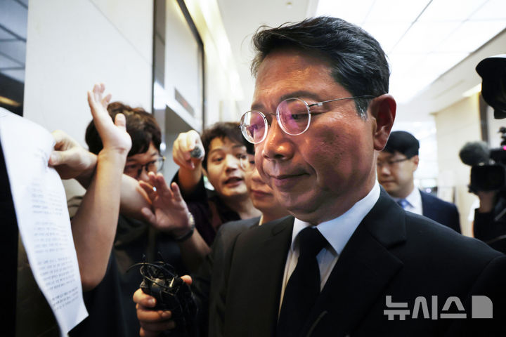 [서울=뉴시스] 조수정 기자 = 김승원 법무부 장관 후보자가 14일 오전 서울 종로구에 마련된 인사청문회 준비사무실로 출근하며 청년 유튜버들이 들이대는 항의 성명서를 보고 있다. 2026.09.14. chocrystal@newsis.com