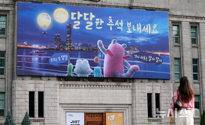 [서울=뉴시스] 이영환 기자 =14일 오전 서울 중구 서울도서관 외벽 서울꿈새김판이 '달달한 추석 보내세요'라는 문구로 꾸며져 있다. 꿈새김판에는 한강 야경을 배경으로 보름달과 서울달을 바라보는 해치와 소울 프렌즈의 모습이 담겼다. 2026.09.14. 20hwan@newsis.com