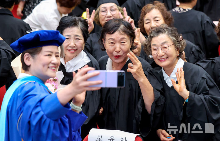 [대구=뉴시스] 이무열 기자 = 14일 대구 수성구 대구시교육청 행복관에서 열린 ‘대구내일학교 초등 제14회·중학 제11회 졸업식’에서 강은희 대구시교육감이 졸업생들과 셀카를 찍고 있다. 내일학교는 배움의 시기를 놓친 성인을 위해 대구시교육청이 초·중등 학력 인정 프로그램을 운영하는 교육기관이다. 2026.09.14. lmy@newsis.com