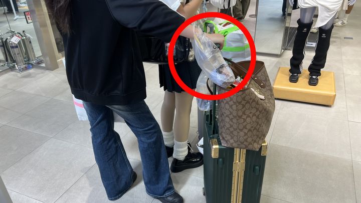 [서울=뉴시스] 중국 광저우에서 온 주정정씨가 서울 중구 명동에서 캐리어를 끌고 이동하고 있다. 길거리에서 쓰레기통을 찾지 못한 주정정씨의 손목에는 커피가 든 비닐 캐리어가 걸려있다. *재판매 및 DB 금지