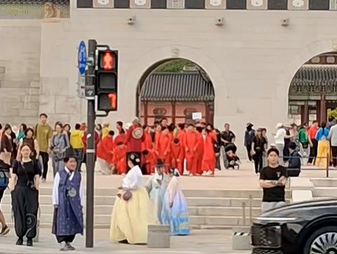 [서울=뉴시스]빨간색 중국 전통풍 상하의를 맞춰 입은 관광객 수십 명이 경복궁 광화문 앞 광장을 거니는 모습 사진 유튜브 채널 '서울삼촌TV' 영상 캡처 *재판매 및 DB 금지