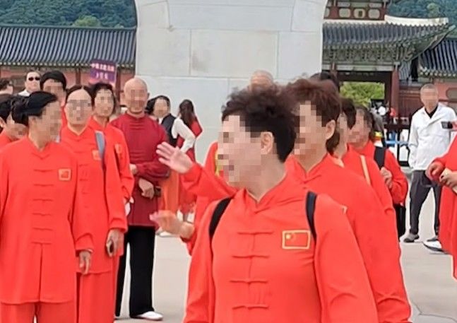 [서울=뉴시스]빨간색 중국 전통풍 상하의를 맞춰 입은 관광객 수십 명이 경복궁 광화문 앞 광장을 거니는 모습. 이들이 입은 상의 가슴 부위에는 중국 국기인 오성홍기 패치가 붙어 있었다. 사진 유튜브 채널 '서울삼촌TV' 캡처 *재판매 및 DB 금지