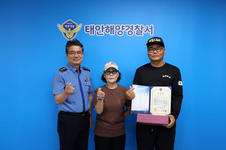 [태안=뉴시스] 정의석(오른쪽)씨가 15일 태안해양경찰서장 집무실에서 하태영 서장에게 감사장을 받은 뒤 아내와 함께 기념 사진을 찍고 있다. (사진=태안해양경찰서 제공) 2026.09.15. photo@newsis.com *재판매 및 DB 금지