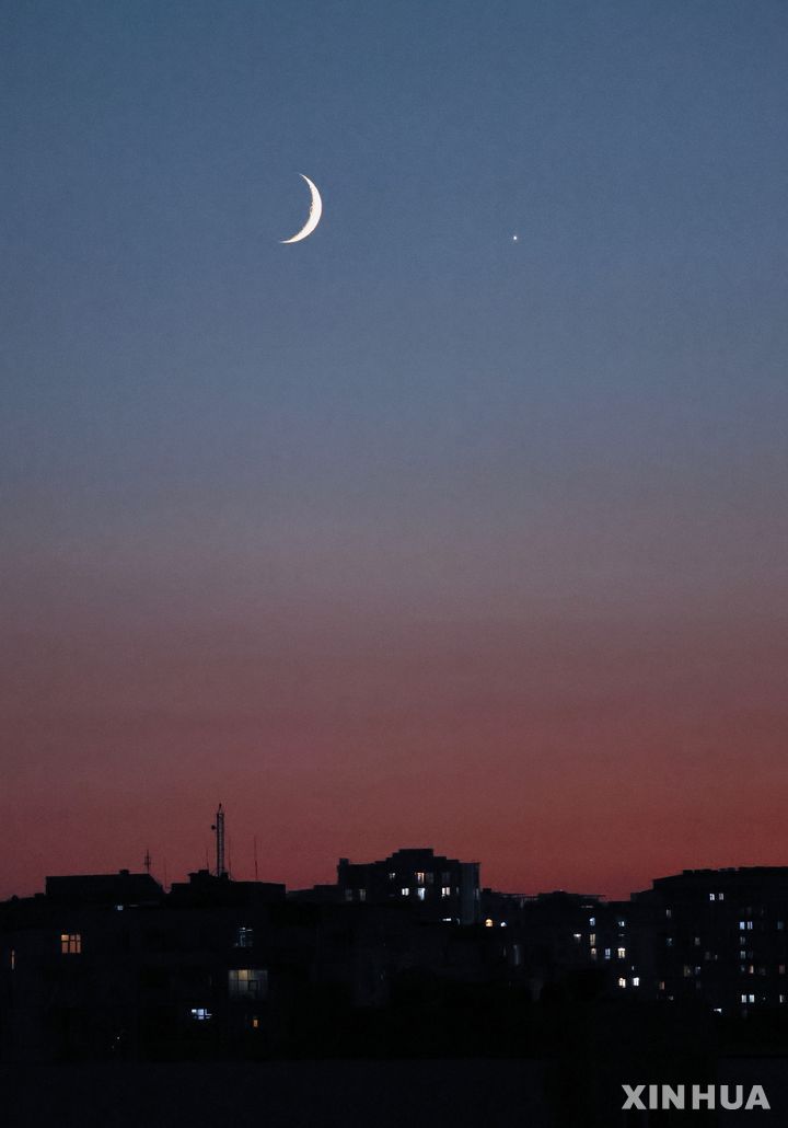 [바쿠=신화/뉴시스] 14일(현지 시간) 아제르바이잔 바쿠 상공에 달과 금성(오른쪽)이 나란히 관측되고 있다. 2026.09.15.