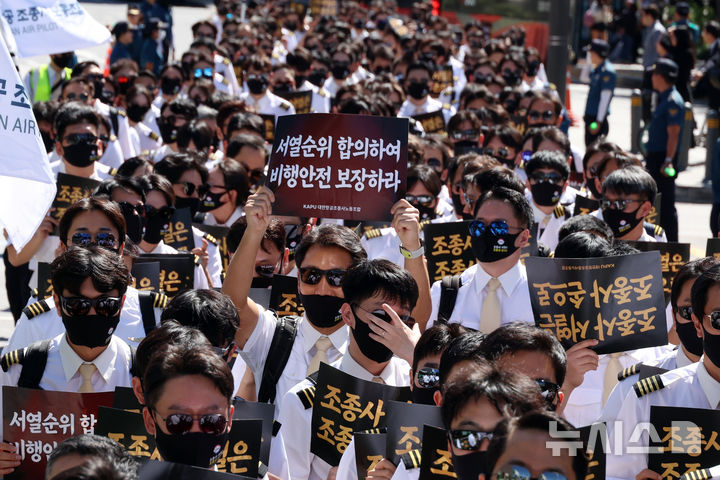 [서울=뉴시스] 고승민 기자 = 대한항공 조종사 노동조합 조합원들이 15일 서울 동화면세점 앞에서 아시아나항공과의 통합 과정 중 운항승무원 서열순위 제도를 준수할 것을 촉구하는 집회를 열고 가두행진을 하고 있다. 2026.09.15. kkssmm99@newsis.com
