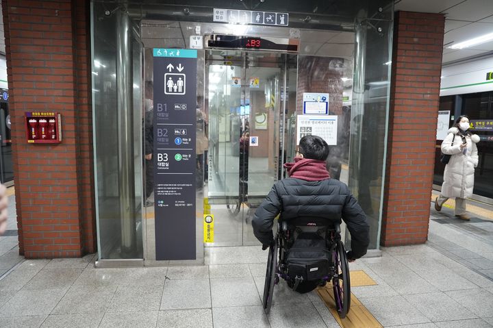 [서울=뉴시스] 서울교통공사가 개선한 교통약자 안내표지를 휠체어 이용자가 살펴보고 있다. (사진=서울교통공사 제공) 2026.01.21. photo@newsis.com *재판매 및 DB 금지