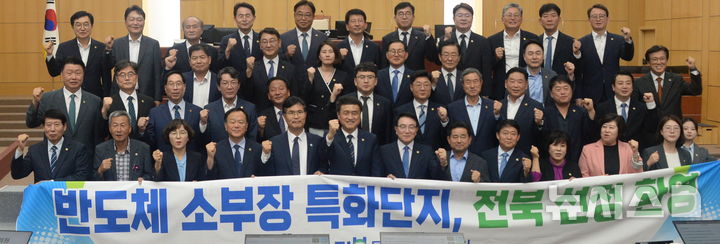 [전주=뉴시스] 김얼 기자 = 김희수(앞줄 가운데) 전북특별자치도의회 의장을 비롯한 전북특별자치도의회 의원들이 18일 전북 전주시 전북특별자치도의회 본회의장에서 본회의 개회에 앞서 '전북 반도체 소부장 특화단지 지정 환영' 퍼포먼스를 하고 있다. 2026.09.18. pmkeul@newsis.com