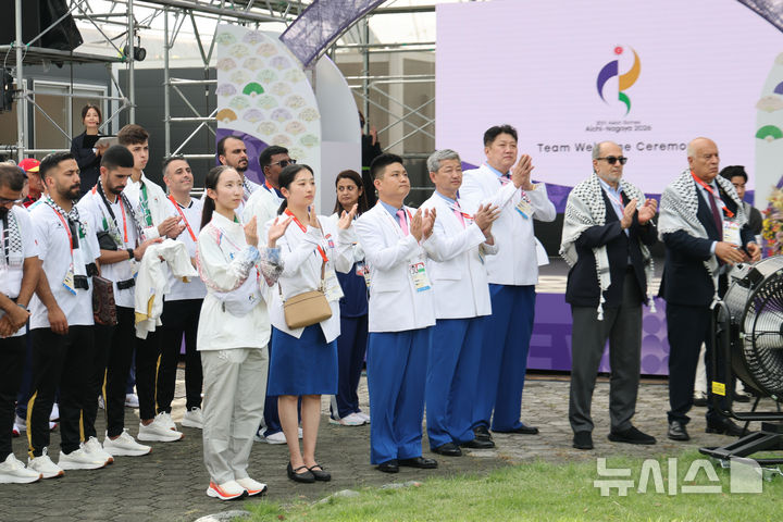 [나고야=뉴시스] 황준선 기자 = 박천종 선수단장을 비롯한 북한 선수단이 18일 오후 일본 나고야향 인근에 마련된 2026 아이치·나고야 아시안게임 선수촌에서 열린 입촌식에서 인공기 게양을 바라보며 손뼉치고 있다. 2026.09.18. hwang@newsis.com