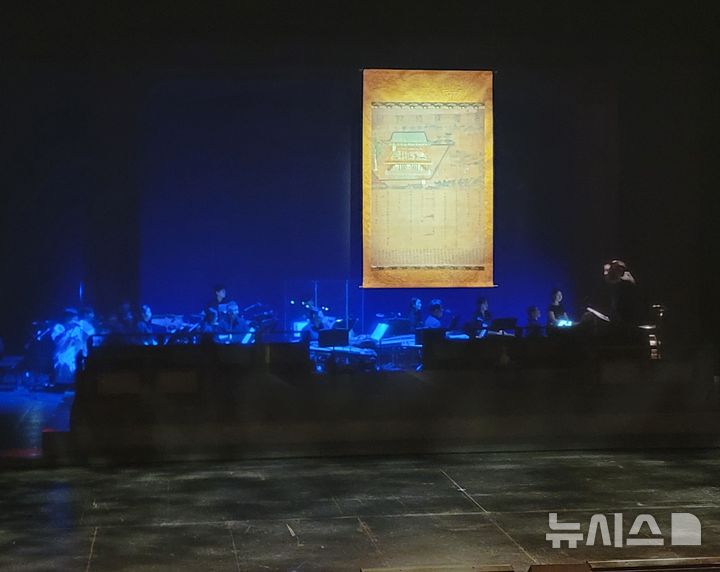 [서울=뉴시스]최희정 기자= 17일 서울 중구 국립극장 달오름극장에서 창무극 '희경루방회도'가 시작되기 전 무대 모습. 극의 모티브가 된 450여 년 전 고화(古畫) '희경루방회도'가 무대 배경으로 걸려 있는 가운데, 연주석에서 악단이 국악을 연주하고 있다. 2026.09.17. dazzling@newsis.com