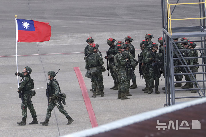 [타오위안=AP/뉴시스] 홍콩 사우스차이나모닝포스트(SCMP)는 19일 복수의 소식통을 인용해 도널드 트럼프 미국 행정부가 오는 11월 중국 선전에서 열리는 아시아태평양경제협력체(APEC) 정상회의 이후로 대만 무기 판매 발표를 미루는 방안을 검토하고 있다고 보도했다. 사진은 2023년 7월26일 대만 북부 타오위안 국제공항에서 공항 피습 상황을 가정해 열린 연례 한광훈련 중 한 대만 군인이 국기를 들고 있는 모습. 2026.09.19.