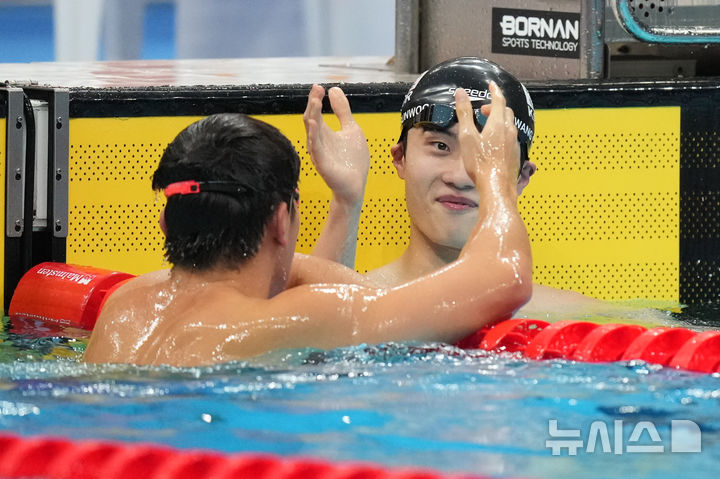 [도쿄=AP/뉴시스] 황선우(오른쪽)가 20일 일본 도쿄 아쿠아틱스센터에서 열린 2026 아이치·나고야 아시안게임 수영 남자 자유형 100ｍ 예선 경기를 마친 뒤 1위로 골인한 판잔러(중국)와 하이 파이브하고 있다. 황선우는 48초13을 기록해 2위로 골인하며 결선에 올랐다. 2026.09.20.