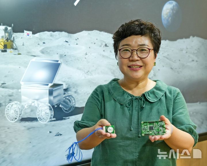 [창원=뉴시스]한국전기연구원(KERI) 항공모빌리티추진연구팀 이지영 박사가 선행 기술 연구를 진행하고 있는 '로버'용 모터와 전력변환장치를 들고 포즈를 취하고 있다.(사진=한국전기연구원 제공)2026.09.20. photo@newsis.com