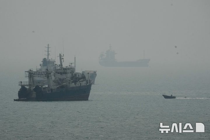 [반다르아바스=AP/뉴시스] 20일(현지 시간) 이란 타스님통신 등에 따르면 이란 통계청은 2026년 1분기(3월21일~6월20일) 실질 국내총생산(GDP)은 전년 동기 대비 10.1% 감소했다고 발표했다. 사진은 지난 7일(현지 시간) 이란 반다르아바스 인근 호르무즈 해협에서 닻을 내린 상선들 사이로 모터보트 한 대가 지나가는 모습. 2026.09.21.