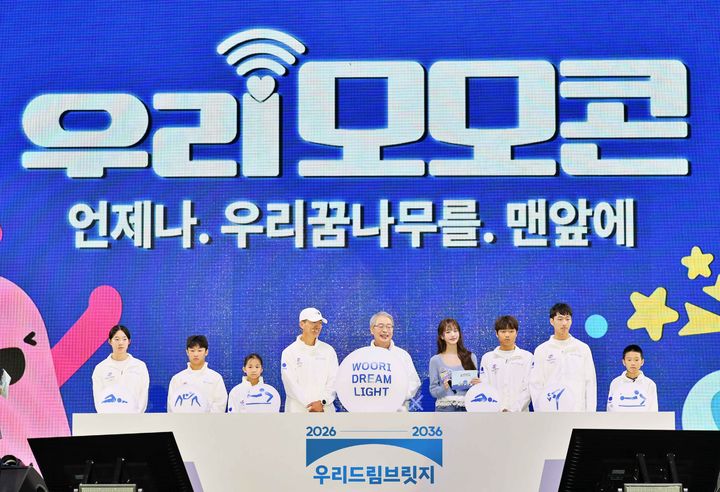 19일 과천 서울랜드에서 열린 '2026 우리 모모콘'에서 임종룡 우리금융그룹 회장(왼쪽 다섯 번째)과 우리은행 앰배서더인 장원영(오른쪽 네 번째), 가수 션(왼쪽 네 번째) 등이 '우리드림브릿지' 후원 선수들과 함께 스포츠 사회공헌 사업을 선포하고 있다. (사진=우리금융 제공) *재판매 및 DB 금지