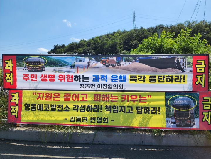 [강릉=뉴시스] 강원 강릉시 강동면 주민들이 인근 발전소로 납품되는 우드펠렛 운송 차량들의 과적으로 인해 피해를 소소하는 현수막을 게시한 모습.2026.9.21.grsoon815@newsis.com *재판매 및 DB 금지
