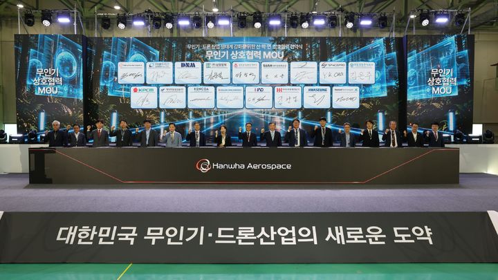 [서울=뉴시스] 경남 창원특례시 한화에어로스페이스 창원1사업장에서 열린 산·학·연 상호 협력 협약식에서 무인기 및 드론 업계 관계자들이 기념 촬영하는 모습. (사진=한화에어로스페이스) 2026.09.21 photo@newsis.com *재판매 및 DB 금지 *재판매 및 DB 금지