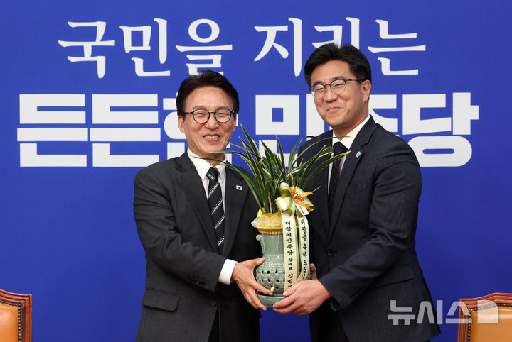 [서울=뉴시스] 고범준 기자 = 김민석 더불어민주당 대표가 21일 서울 여의도 국회에서 오준호 기본소득당 대표를 접견하며 축하난을 전달한 뒤 기념촬영 하고 있다. 2026.09.21. bjko@newsis.com