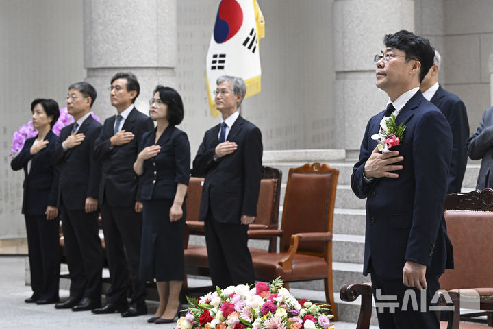[서울=뉴시스] 홍효식 기자 = 김성수 신임 대법관과 조희대 대법원장 등 대법관들이 21일 서울 서초구 대법원에서 열린 신임 대법관 취임식에서 국기에 대한 경례를 하고 있다.