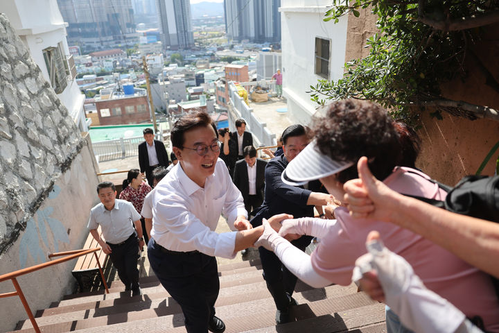 [부산=뉴시스]전재수 부산시장이 동구 산복도로의 좁고 가파른 계단을 올라 주민들과 인사를 하고 있다. (사진=부산시 제공) 2026.09.22. photo@newsis.com *재판매 및 DB 금지