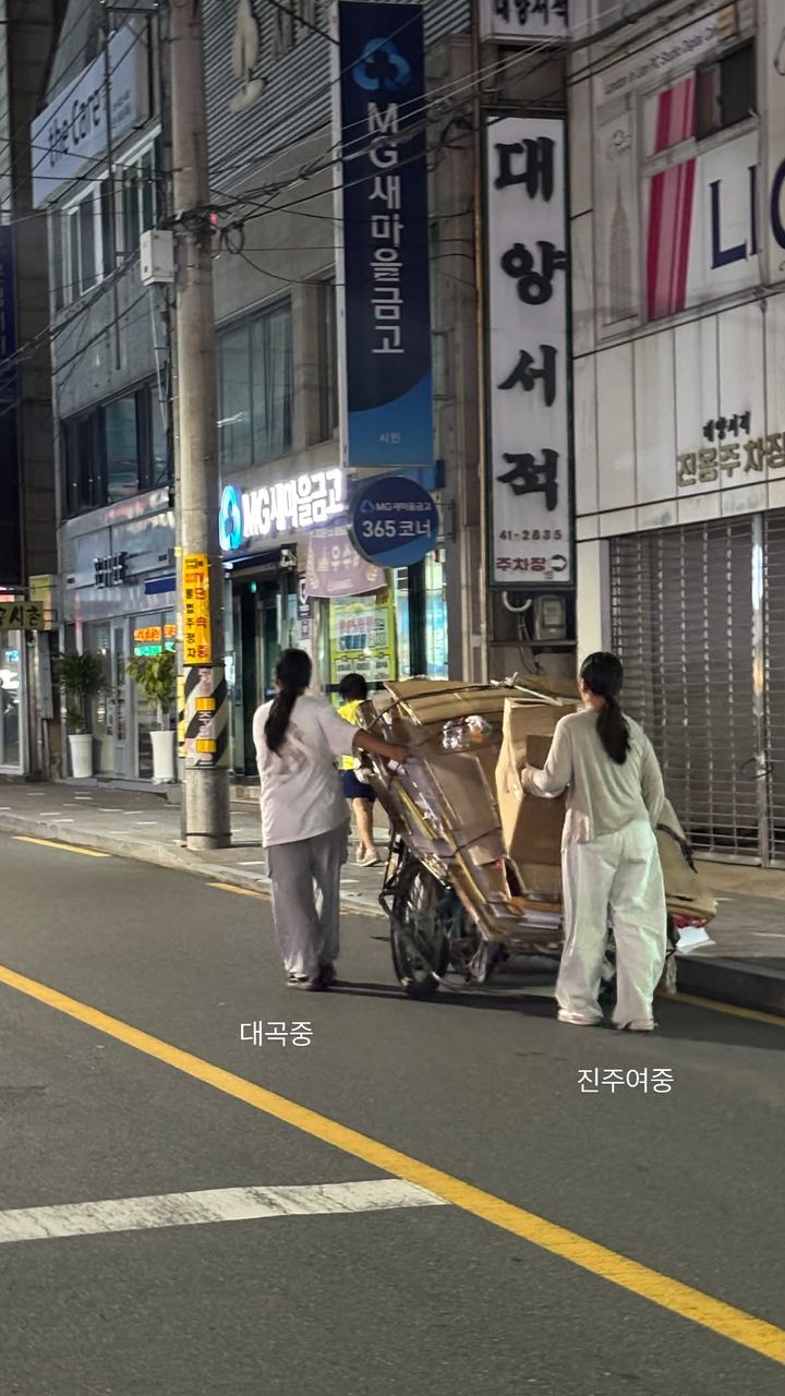 [서울=뉴시스] 두 여중생이 폐지가 실린 리어카를 끌며 노인을 도와 고물상까지 동행하고 있다. (사진=SNS 캡처) *재판매 및 DB 금지