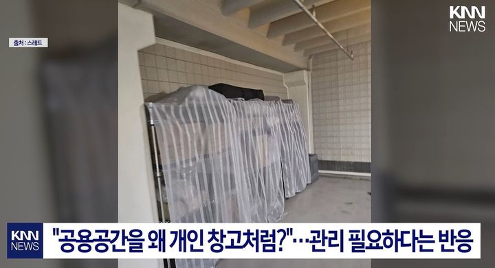 [서울=뉴시스] 아파트 지하 주차장에 선반과 커튼까지 설치하고 각종 물건을 쌓아둔 모습이 포착돼 공용 공간의 사적 사용을 둘러싼 논란이 일고 있다. (사진=KNN 캡처) *재판매 및 DB 금지