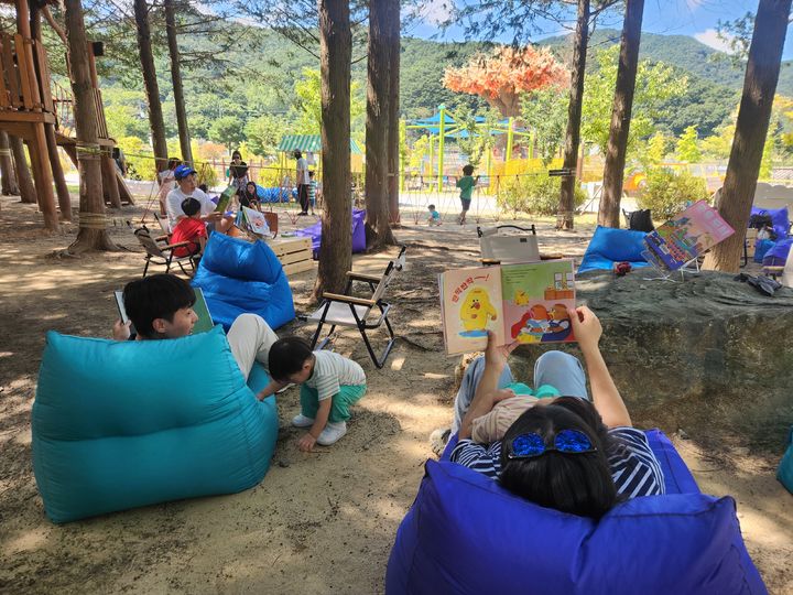 [정읍=뉴시스] 정읍시립중앙도서관이 지난 19일 내장산 워터파크 편백도시숲에서 진행한 '쉼표, 숲속 야외도서관' 프로그램 참여자들 숲속 편안한 모습으로 책을 보고 있다. *재판매 및 DB 금지