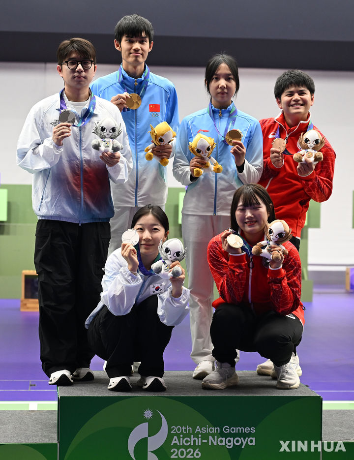 [도요타=신화/뉴시스] 한국 공기소총 박하준-반효진(왼쪽)이 22일 일본 아이치현 도요타에서 열린 2026 아이치·나고야 아시안게임 사격 10m 공기소총 혼성 단체전에서 은메달을 따낸 뒤 시상대에 올라 다른 수상자들과 함께 기념 촬영하고 있다. 박하준과 반효진은 결선에서 502.9점을 합작하며 2위에 올랐다. 2026.09.22.