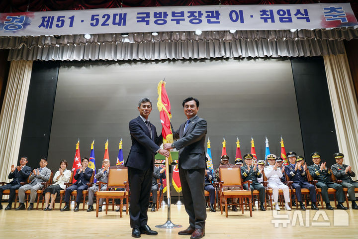 [서울=뉴시스] 김명년 기자 = 강신철(왼쪽) 신임 국방부 장관이 22일 오후 서울 용산구 국방부에서 열린 제51대·52대 국방부장관 이·취임식에서 안규백 전 장관으로 부터 국방부기를 이양받고 있다. 2026.09.22. kmn@newsis.com