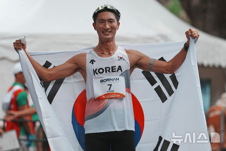 [나고야=AP/뉴시스] 최병광이 23일 일본 나고야에서 열린 2026 아이치·나고야 아시안게임 남자 하프마라톤 경보에서 3위를 차지한 뒤 태극기를 몸에 두르고 포즈를 취하고 있다. 최병광은 1시간28분35초로 동메달을 목에 걸어 육상 종목 첫 메달을 따냈다. 2026.09.23.