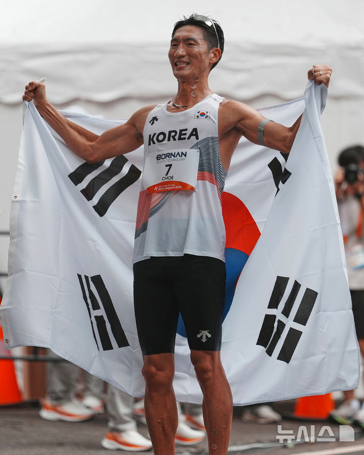 [나고야=AP/뉴시스] 최병광이 23일 일본 나고야에서 열린 2026 아이치·나고야 아시안게임 남자 하프마라톤 경보에서 3위를 차지한 뒤 태극기를 몸에 두르고 기뻐하고 있다. 최병광은 1시간28분35초로 동메달을 목에 걸어 육상 종목 첫 메달을 따냈다. 2026.09.23.