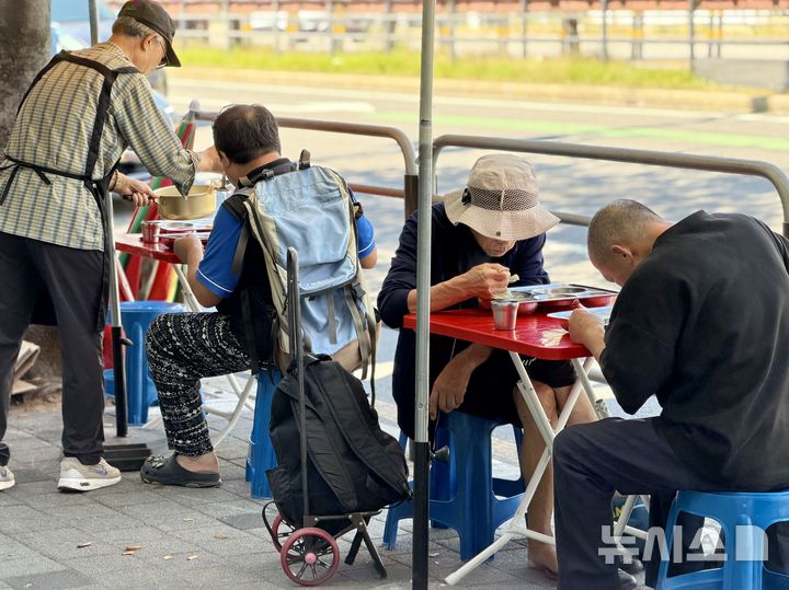 [서울=뉴시스] 추석 연휴를 앞둔 지난 22일 서울 영등포구 무료급식소 '토마스의 집'에서 노인들이 야외에 마련된 자리에 앉아 점심 식사를 하고 있다. 2026.09.25. photo@newsis.com