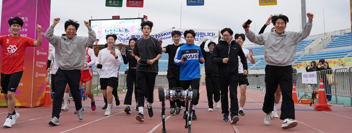 [대전=뉴시스] 라이보2가 지난 2024년 11월 경북서 열린 상주 곶감 마라톤 대회에서 배터리 재충전이나 교체 없이 풀코스 42.195㎞를 완주, 개발 연구진과 결승선을 들어오고 있는 모습.(사진=KAIST 제공) *재판매 및 DB 금지