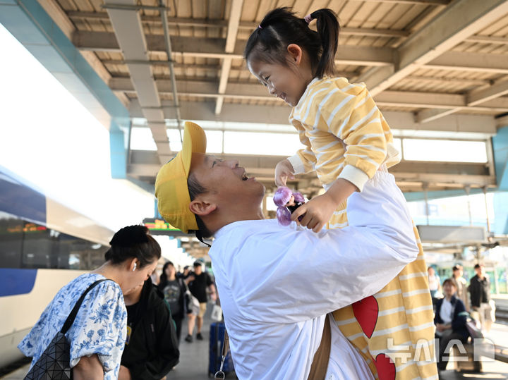 [전남광주=뉴시스] 이현행 기자 = 추석 연휴를 하루 앞둔 23일 오전 광주 광산구 광주송정역에서 한 아빠가 자식을 보고 반가워하고 있다. 2026.09.23. lhh@newsis.com