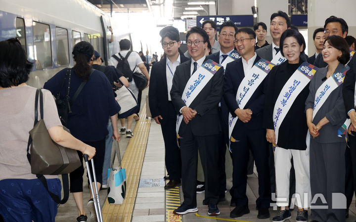 [서울=뉴시스] 고범준 기자 = 김민석 더불어민주당 대표와 한병도 원내대표를 비롯한 여당 의원들이 추석 연휴를 하루 앞둔 지난 23일 오전 서울 용산역을 찾아 열차에 탑승한 귀성길 시민들에게 인사하고 있다. (공동취재) 2026.09.23. photo@newsis.com