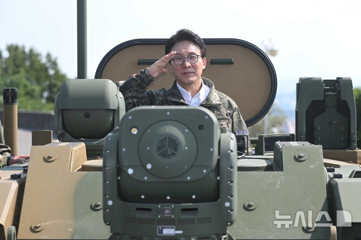 [서울=뉴시스] 국회사진기자단 = 김민석 더불어민주당 대표가 23일 오후 경기 김포시 공군3미사일방어여단 예하부대를 방문해 30mm 차륜형 대공포 천호에 탑승해 경례를 하고 있다. 2026.09.23. photo@newsis.com
