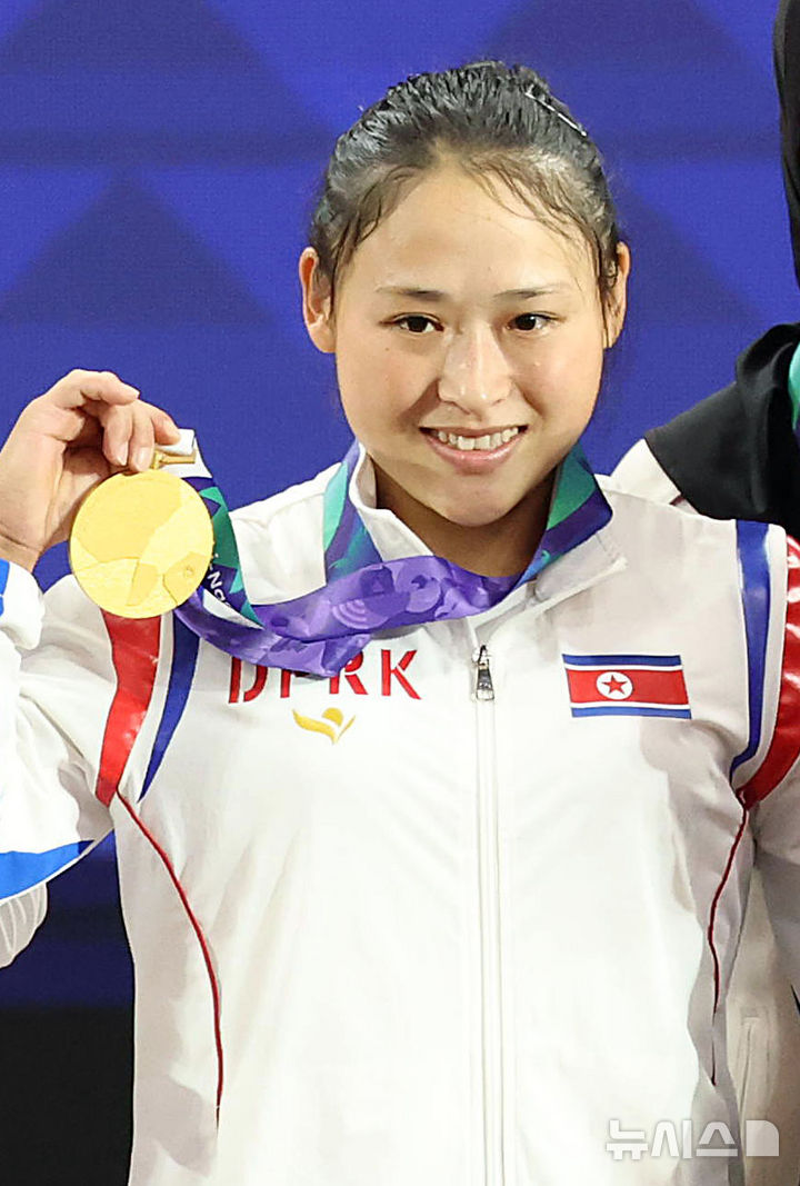 [나고야(일본)=뉴시스] 황준선 기자 = 23일(현지 시간) 일본 아이치현 나고야시 중소기업진흥회관에서 열린 2026 아이치·나고야 아시안게임 역도 여자 49kg급 시상식에서 금메달을 획득한 북한 리성금이 기념촬영을 하고 있다. 2026.09.23. hwang@newsis.com
