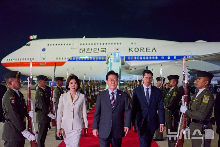 [숨팡고=뉴시스] 김진아 기자 = 이재명 대통령과 김혜경 여사가 23일(현지 시간) 멕시코 펠리페 앙헬레스 국제공항에 도착해 환영을 받으며 이동하고 있다. 2026.09.24. bluesoda@newsis.com
