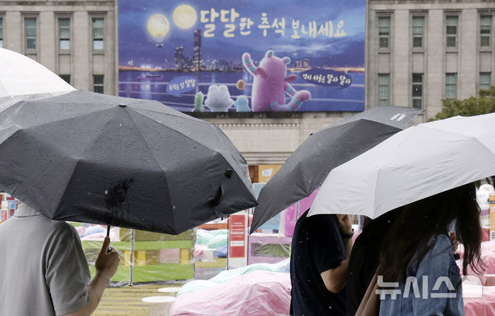 [서울=뉴시스] 최동준 기자 = 비가 내리고 있는 25일 시민과 외국인 관광객이 우산을 쓰고 서울 중구 서울도서관 앞을 지나가고 있다. 2026.09.25. photocdj@newsis.com