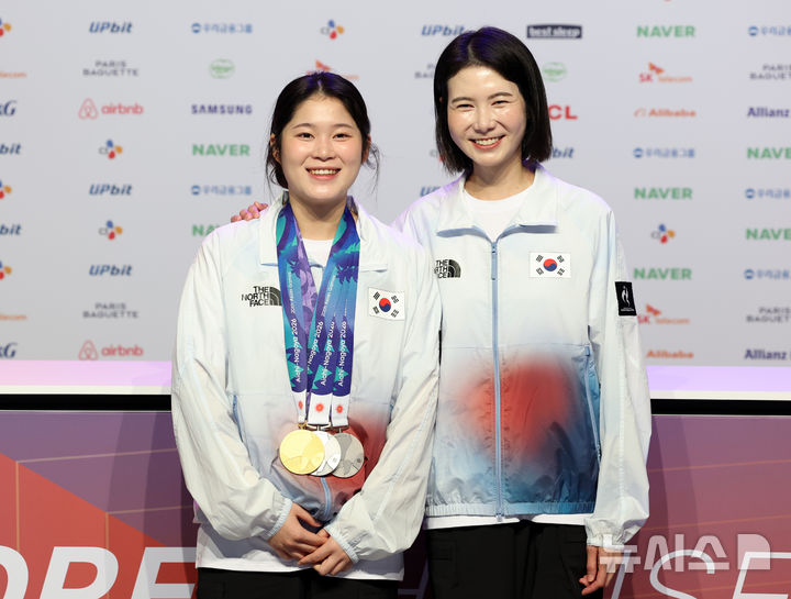 [나고야(일본)=뉴시스] 이영환 기자 = 사격 여자 공기권총 10m 금메달리스트 추가은과 이호림 코치가 26일 오전(현지 시간) 일본 아이치현 나고야시 코리아하우스에서 열린 금메달리스트 기자회견에 참석해 기념촬영을 하고 있다. 2026.09.26. 20hwan@newsis.com