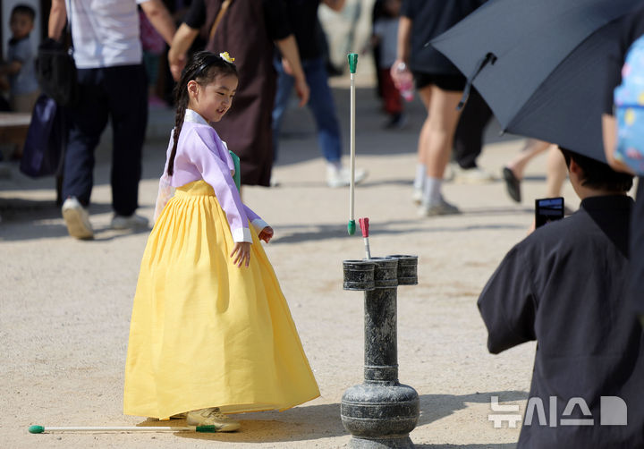 [서울=뉴시스] 홍효식 기자 = 추석 연휴 셋째 날인 26일 서울 중구 남산골한옥마을에서 열린 2026 남산골 추석축제 '남산달빛마당'을 찾은 한 어린이이가 한복을 입고 투호 던지기를 즐기고 있다. 2026.09.26. yesphoto@newsis.com