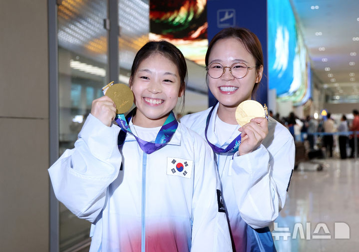 [인천공항=뉴시스] 김선웅 기자 = 2026 아이치·나고야 아시안게임 기계체조 여자 평균대 금메달리스트 황서현과 기계체조 여자 도마 금메달리스트 여서정이 26일 인천국제공항을 통해 귀국해 금메달을 들어보이고 있다. 2026.09.26. mangusta@newsis.com