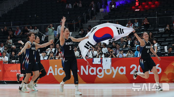 [나고야(일본)=뉴시스] 김금보 기자 = 26일 오후(현지 시간) 일본 아이치현 나고야시에서 열린 2026 아이치·나고야 아시안게임 여자 농구 결승 한국과 일본의 경기, 한국이 75-70으로 승리하며 금메달을 차지했다. 주장 강이슬과 선수들이 태극기를 들고 환호하고 있다. 2026.09.26. kgb@newsis.com