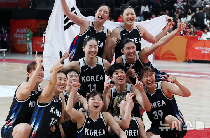 [나고야(일본)=뉴시스] 김금보 기자 = 26일 오후(현지 시간) 일본 아이치현 나고야시에서 열린 2026 아이치·나고야 아시안게임 여자 농구 결승 한국과 일본의 경기, 한국이 75-70으로 승리하며 금메달을 차지했다. 주장 강이슬과 선수들이 태극기를 들고 환호하고 있다. 2026.09.26. kgb@newsis.com