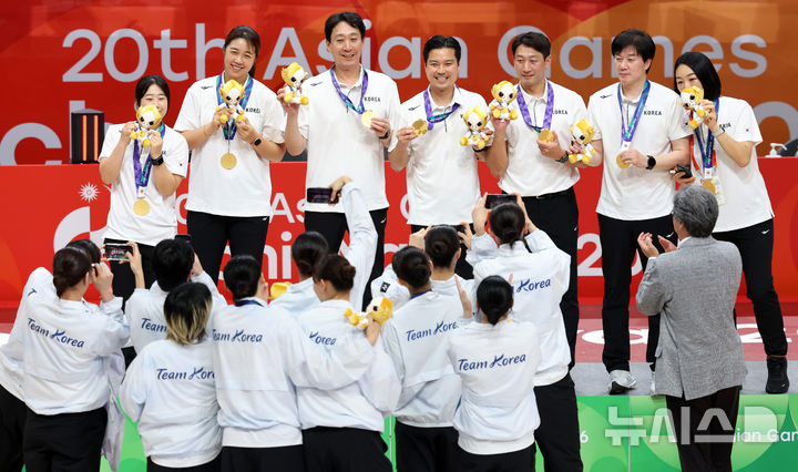[나고야(일본)=뉴시스] 이영환 기자 = 26일 오후(현지 시간) 일본 아이치현 나고야시에서 열린 2026 아이치·나고야 아시안게임 여자 농구 결승 한국과 일본의 경기에서 75-70으로 일본을 꺾고 금메달을 획득한 한국 선수들이 박수호 감독과 코치진에게 메달을 건넨 후 기념촬영을 하고 있다. 2026.09.26. 20hwan@newsis.com