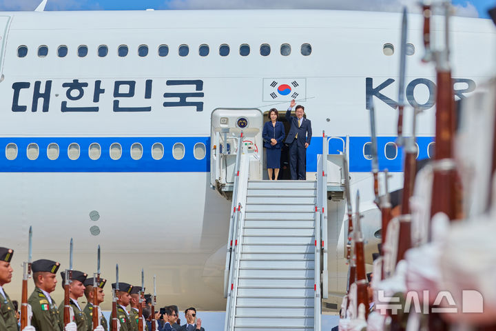 [숨팡고=뉴시스] 김진아 기자 = 멕시코 국빈방문을 마친 이재명 대통령과 김혜경 여사가 26일(현지 시간) 멕시코 펠리페 앙헬레스 국제공항에 도착해 공군 1호기에 올라 인사를 하고 있다. (공동취재) 2026.09.27. bluesoda@newsis.com