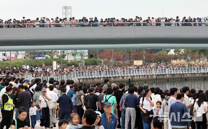  [부산=뉴시스] 하경민 기자 = 추석 연휴 마지막날인 27일 부산 동구 북항 친수공원에서 시민들이 수로에서 유영하는 상어를 구경하고 있다. '부캉이'로 불리는 이 상어가 화제를 모으면서 지난 24일 10만1000명, 25일 13만6000명, 26일 14만명 등 추석 연휴 사흘간 38만명의 관람 인파가 북항 친수공원을 방문했다. 2026.09.27. yulnetphoto@newsis.com